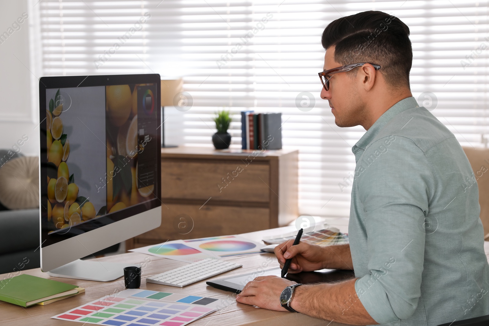 Photo of Professional retoucher working on computer in office