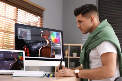 Professional retoucher working on computer in office