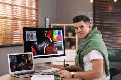 Photo of Professional retoucher working on computer in office