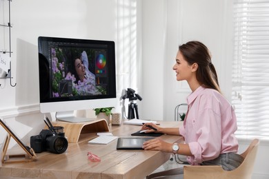 Photo of Professional retoucher working on graphic tablet at desk in office