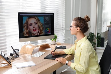 Photo of Professional retoucher working on graphic tablet at desk in office