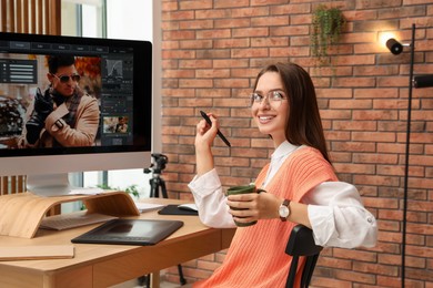 Photo of Professional retoucher working on graphic tablet at desk in office