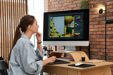 Photo of Professional retoucher working on graphic tablet at desk in office