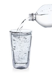 Photo of Pouring soda water from bottle into glass on white background