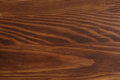 Photo of Applying walnut wood stain. Texture of wooden surface as background, top view