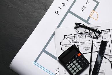 Photo of Different architectural drawings, glasses, calculator and ruler on grey textured table, flat lay