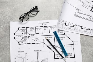 Photo of Different engineering drawings, glasses, pencil and ruler on grey textured table, flat lay