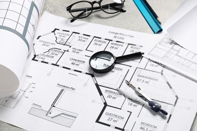 Photo of Different engineering drawings and tools on grey table