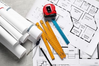 Photo of Different engineering drawings and tools on grey textured table, flat lay