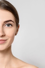 Photo of Beautiful young woman after henna eyebrows dyeing on light background, closeup