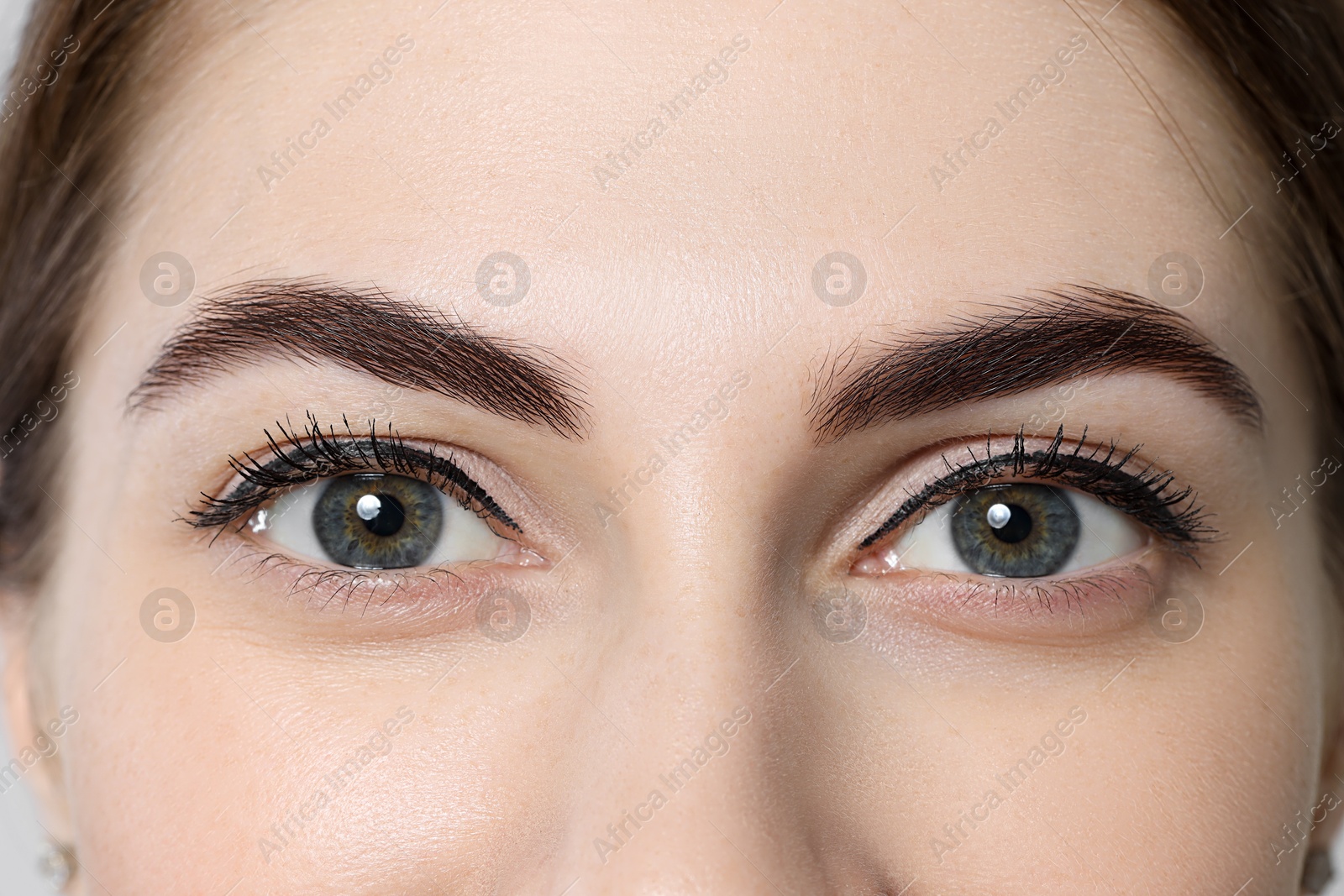 Photo of Beautiful young woman after henna eyebrows dyeing, closeup