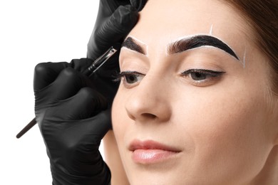 Photo of Young woman undergoing henna eyebrows dyeing procedure on light background, closeup