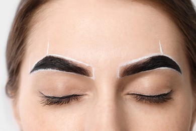 Young woman during henna eyebrows dyeing procedure, closeup