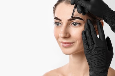 Photo of Young woman undergoing henna eyebrows dyeing on white background, closeup. Space for text