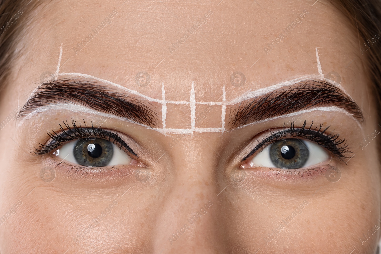 Photo of Young woman during henna eyebrows dyeing procedure, closeup