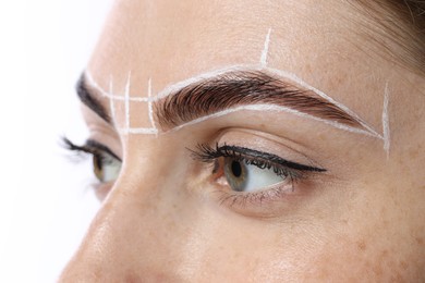 Photo of Young woman during henna eyebrows dyeing procedure on white background, closeup