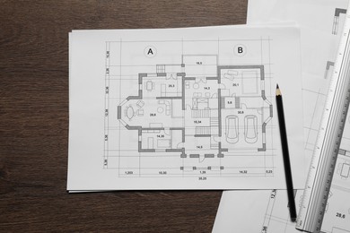 Photo of Different architectural drawings, ruler and pencil on wooden table, top view