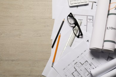 Photo of Different architectural drawings and tools on wooden table, top view. Space for text