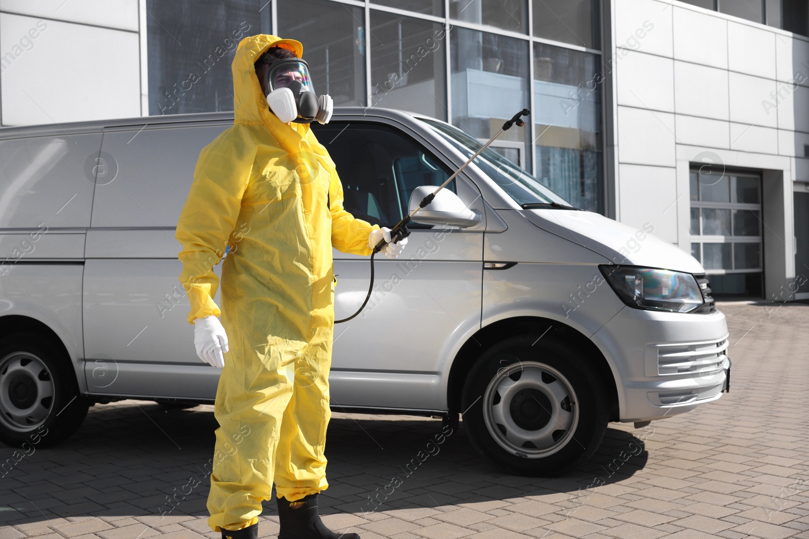 Photo of Pest control worker with spray tank outdoors