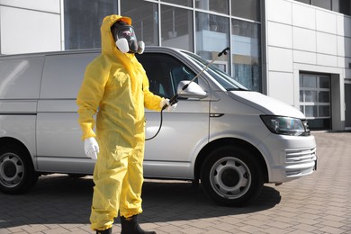 Photo of Pest control worker with spray tank outdoors