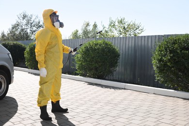 Photo of Pest control worker with spray tank outdoors