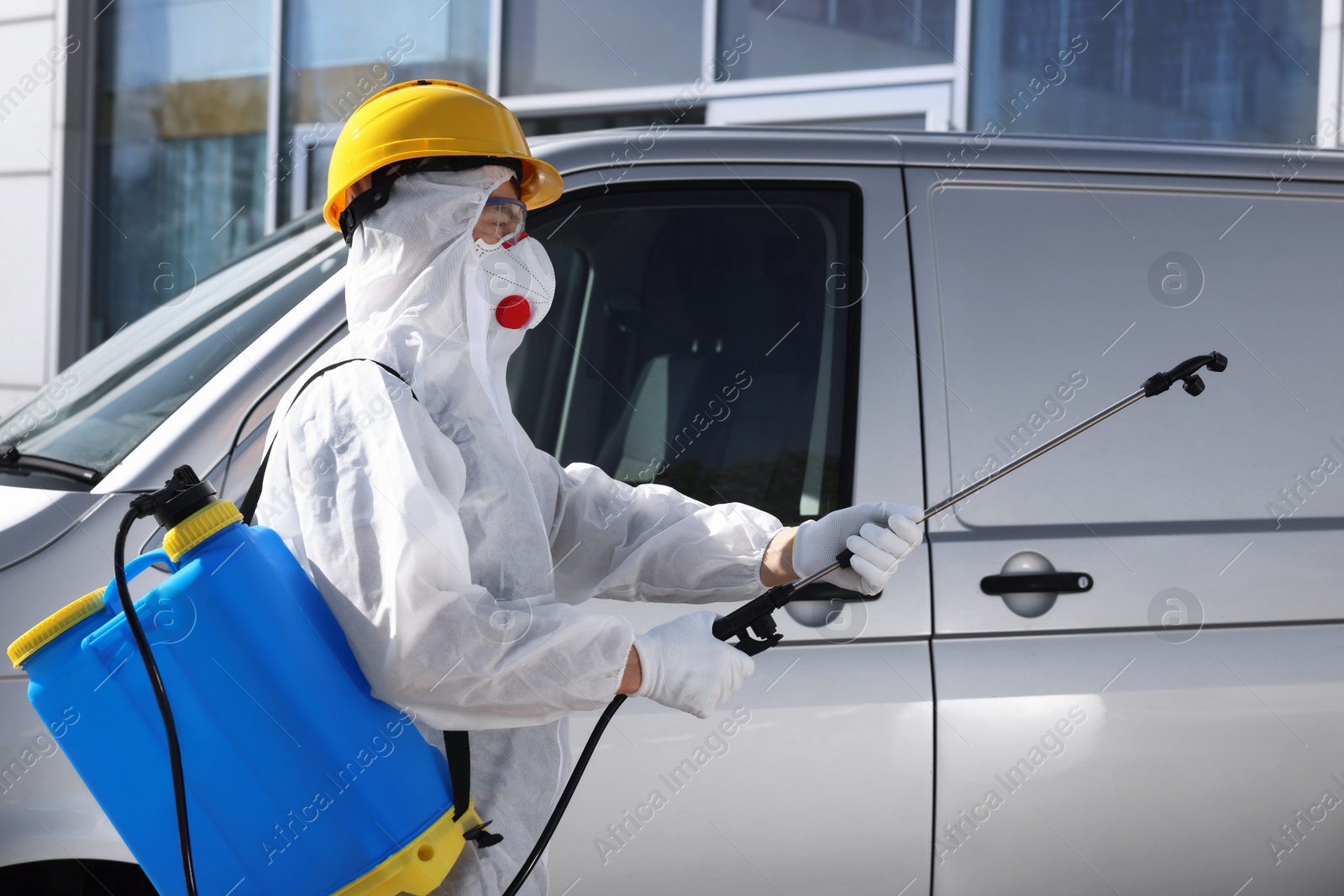 Photo of Pest control worker with spray tank near gray minibus outdoors