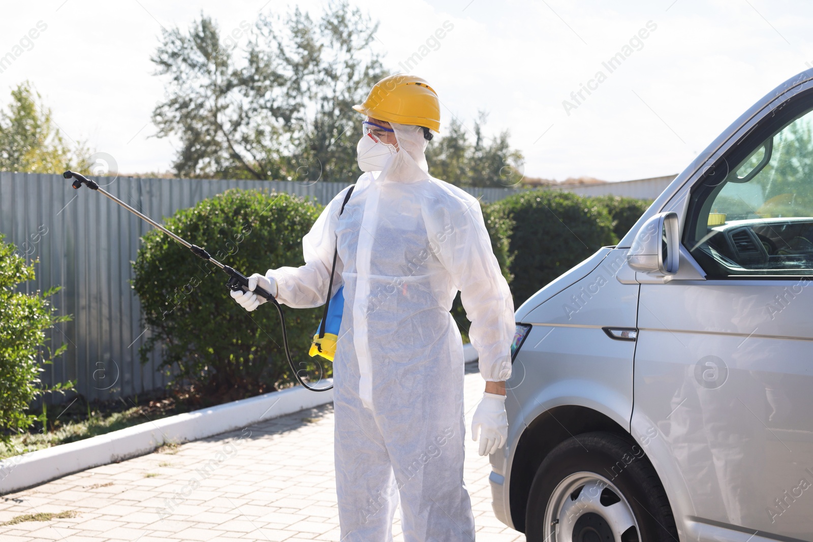 Photo of Pest control worker with spray tank outdoors