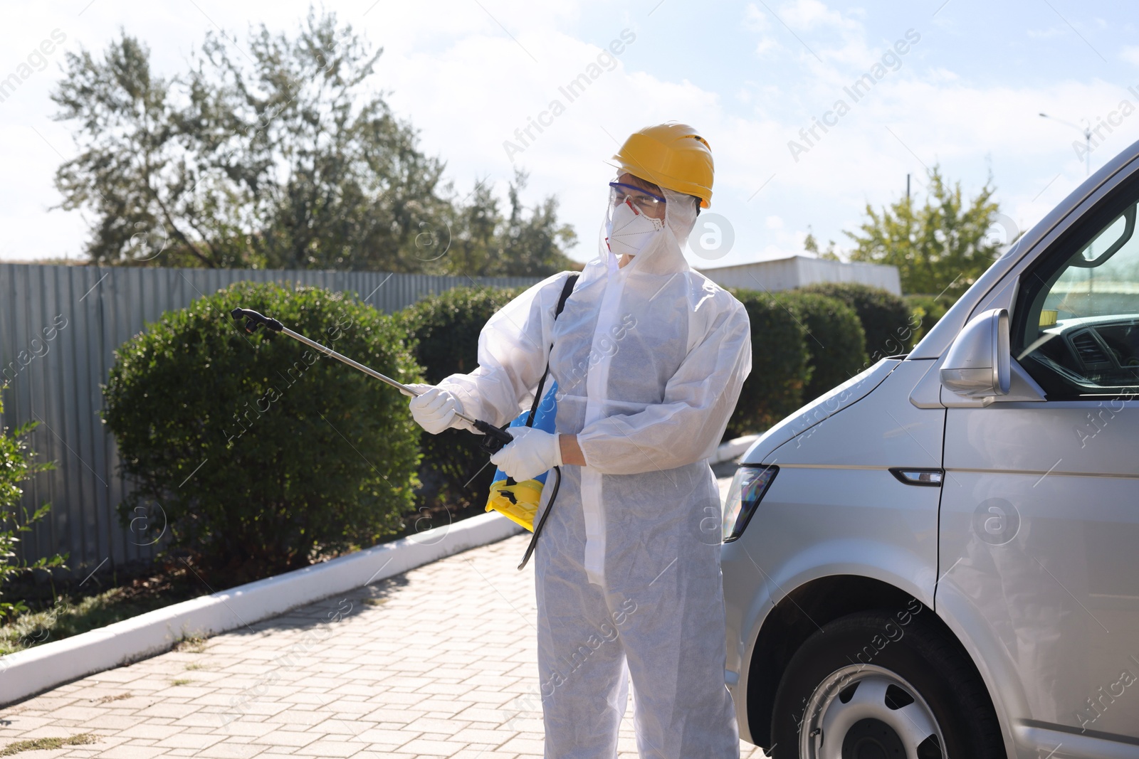 Photo of Pest control worker with spray tank outdoors