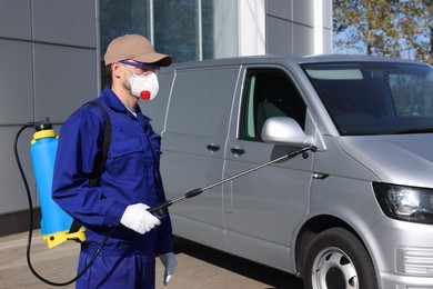 Photo of Pest control worker with spray tank outdoors