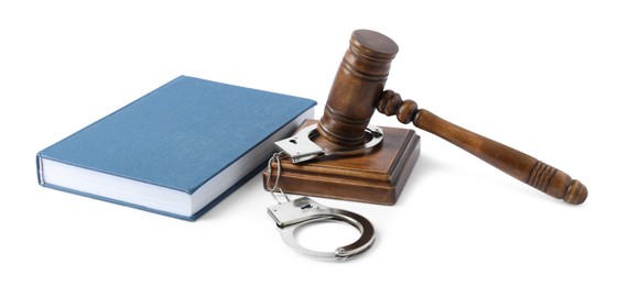 Handcuffs, judge's gavel and book isolated on white