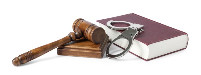 Handcuffs, judge's gavel and book isolated on white