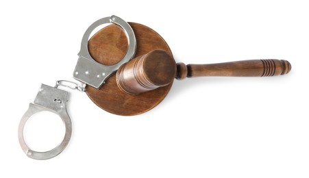 Photo of Handcuffs and judge's gavel isolated on white, top view