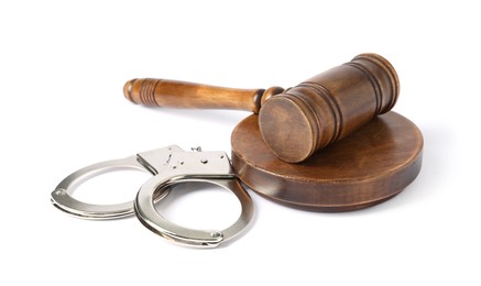 Photo of Handcuffs and judge's gavel isolated on white