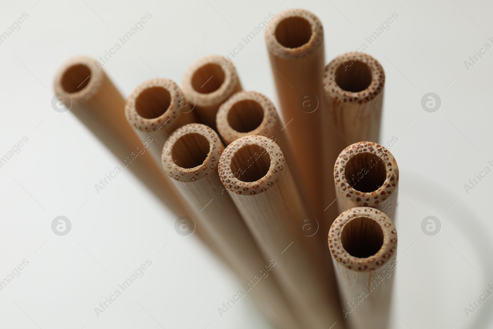 Photo of Bamboo drinking straws on blurred background, closeup