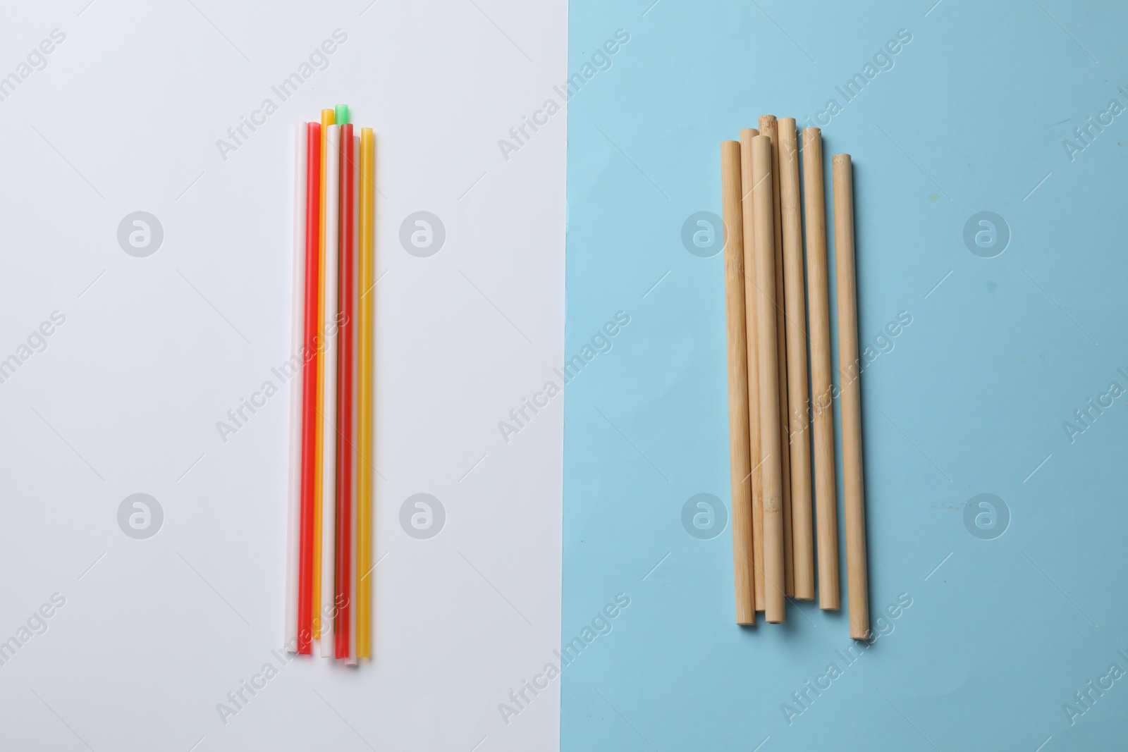 Photo of Plastic and bamboo drinking straws on color background, flat lay