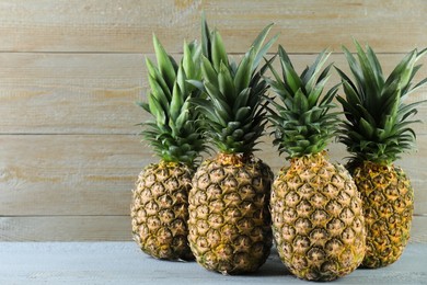 Fresh ripe pineapples on grey wooden table