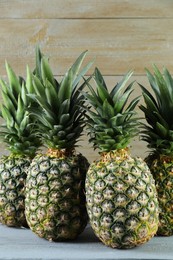 Fresh ripe pineapples on grey wooden table