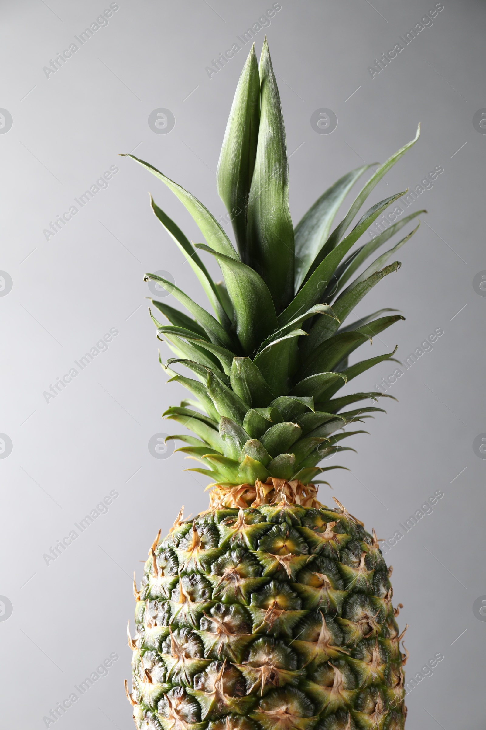 Photo of Fresh ripe pineapple on light grey background, closeup