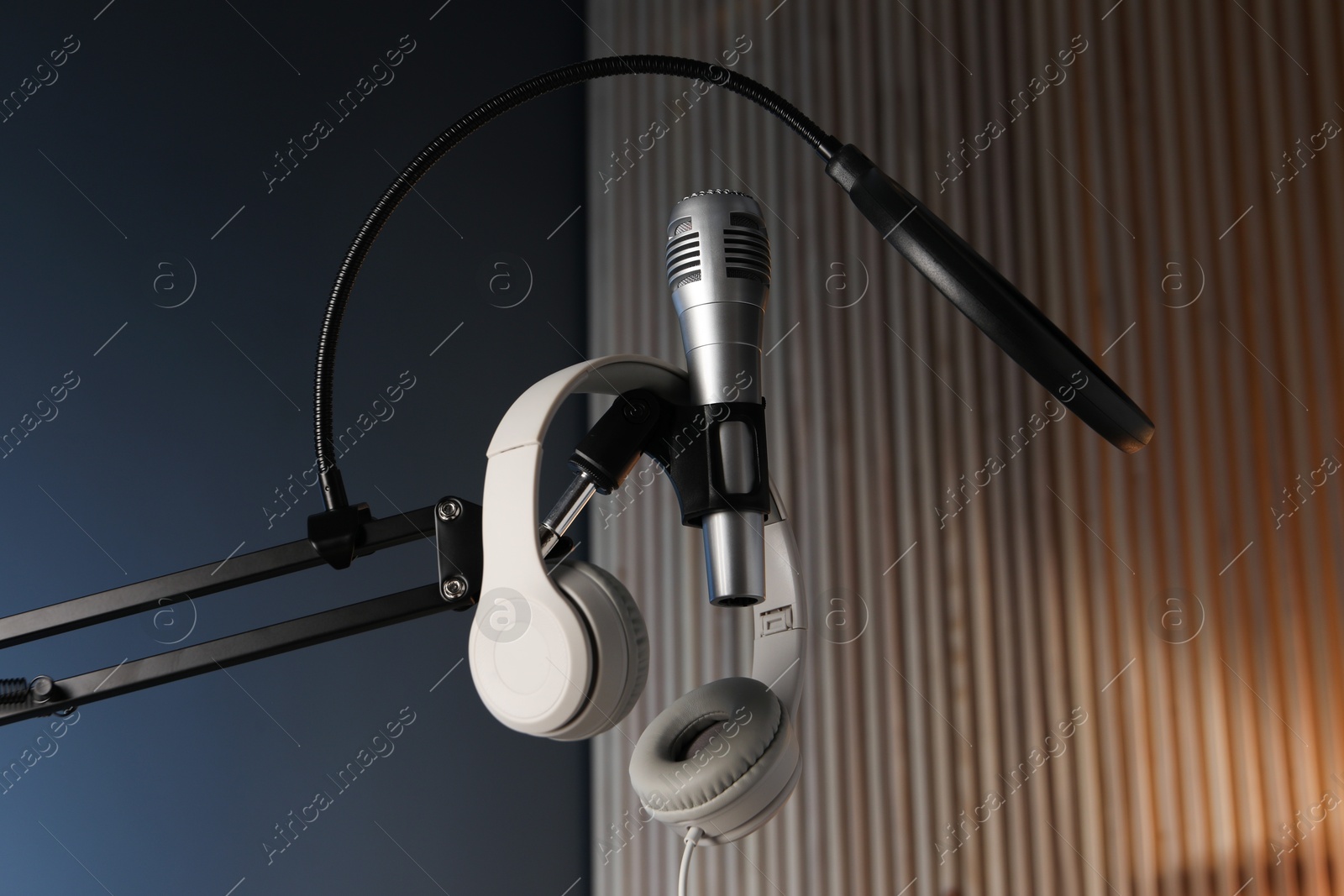 Photo of Stand with microphone, headphones and pop filter indoors, low angle view. Sound recording and reinforcement