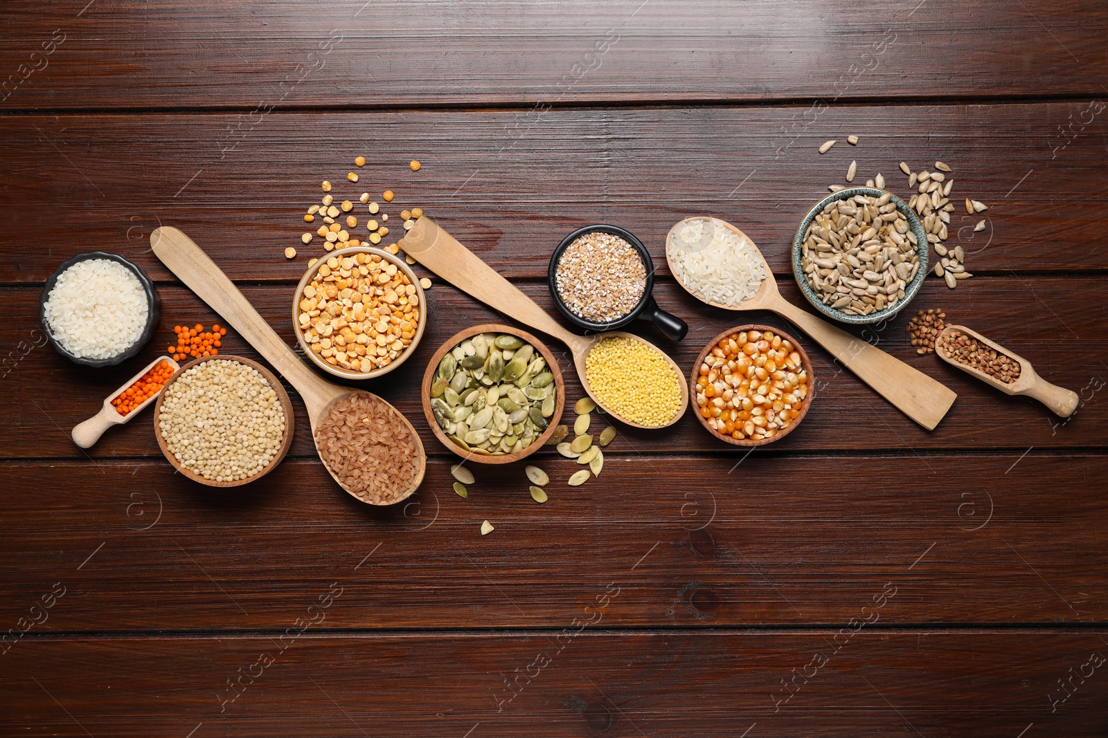 Photo of Different types of legumes, seeds and cereals on wooden table, flat lay