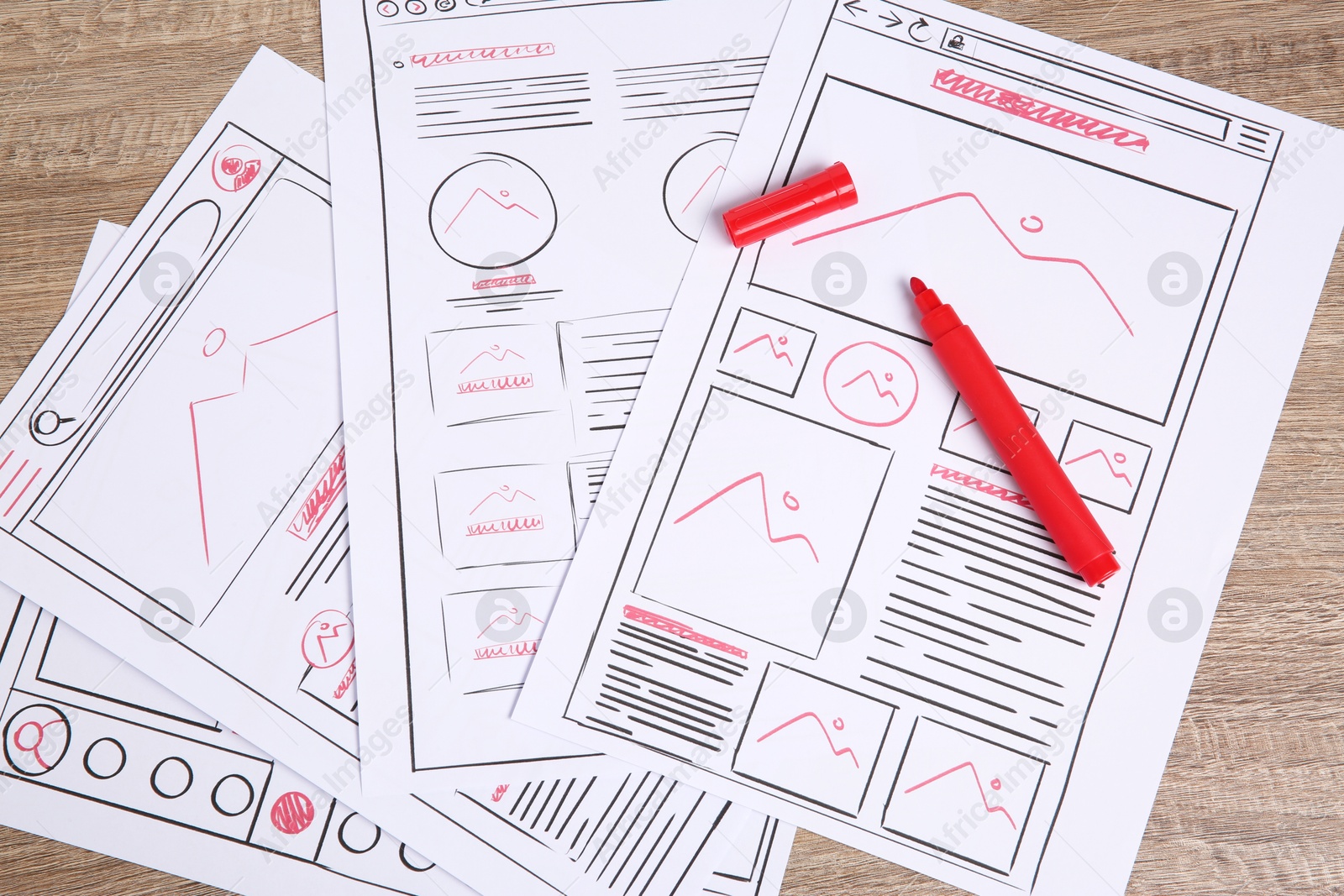 Photo of Developing UI design. Sketches of website wireframes and felt pen on wooden table, top view