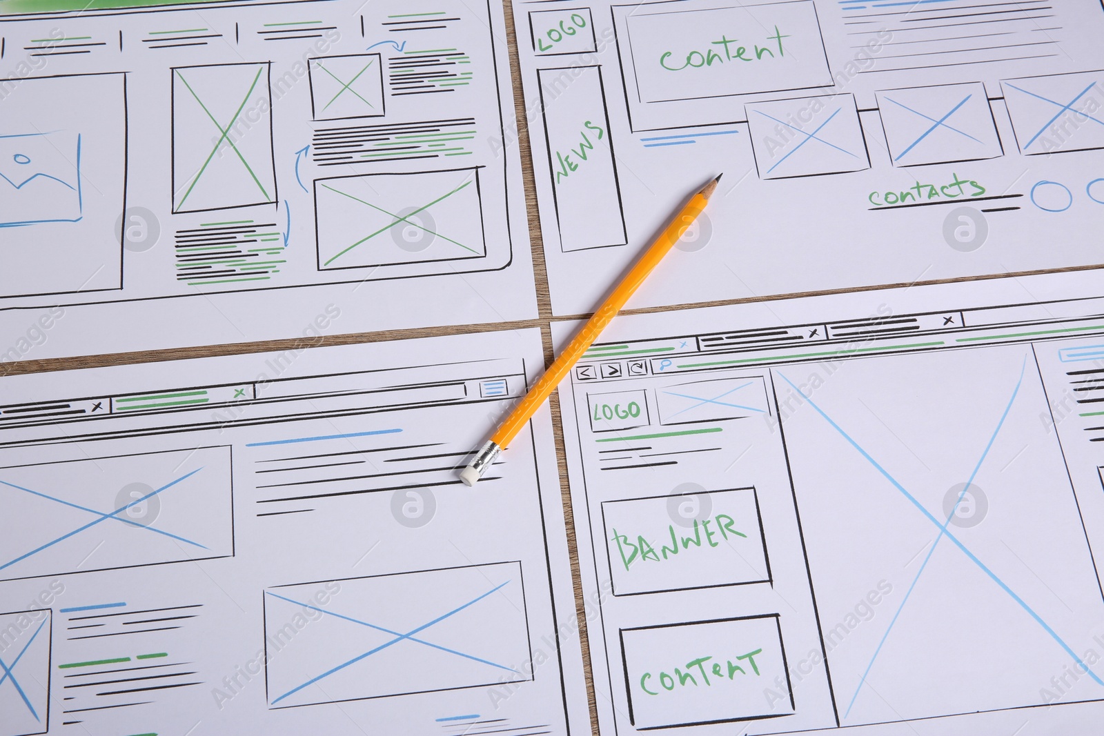 Photo of Developing UI design. Sketches of website wireframes and pencil on table, above view