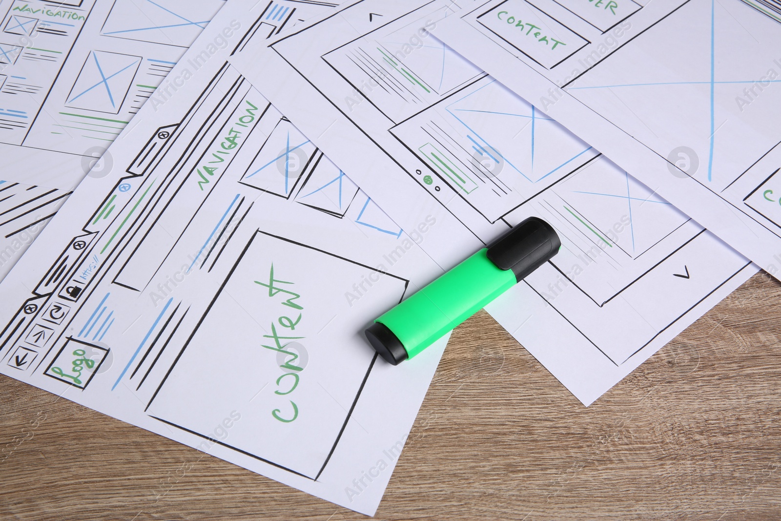 Photo of Developing UI design. Sketches of website wireframes and felt pen on wooden table, closeup