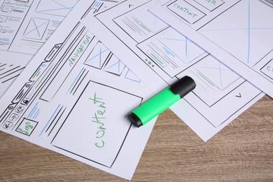 Photo of Developing UI design. Sketches of website wireframes and felt pen on wooden table, closeup