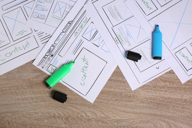 Photo of Developing UI design. Sketches of website wireframes and felt pens on wooden table, top view