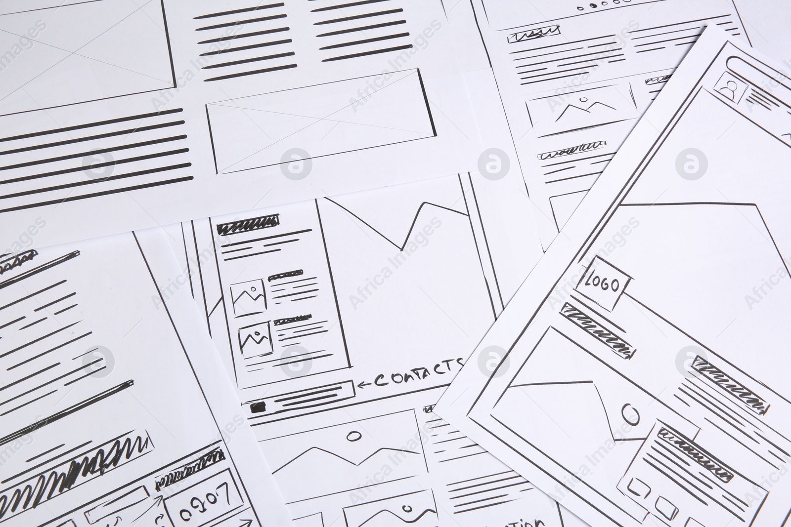 Photo of Developing UI design. Sketches of website wireframes as background, above view