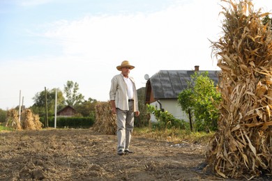 Photo of Senior man near pile of hay outdoors