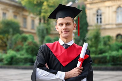 Photo of Student with diploma after graduation ceremony outdoors