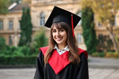 Photo of Graduation ceremony. Happy student in academic dress outdoors