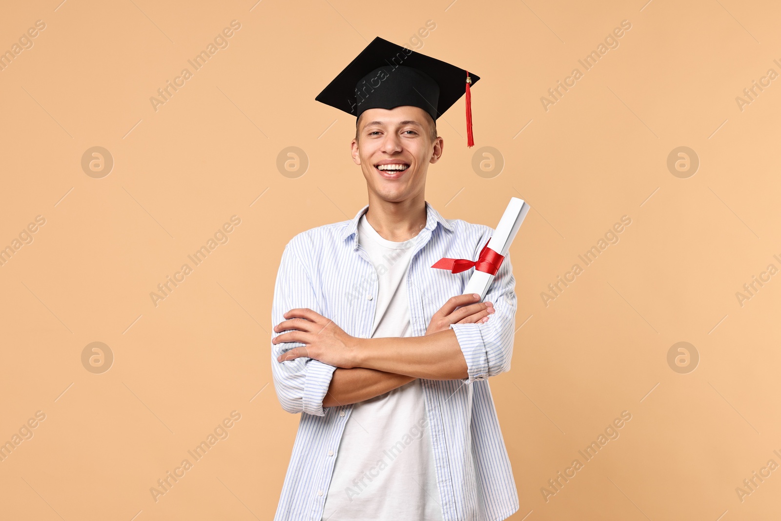 Photo of Happy student with diploma after graduation on beige background